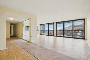 Spare room with parquet floors, floor to ceiling windows, and a mountain view