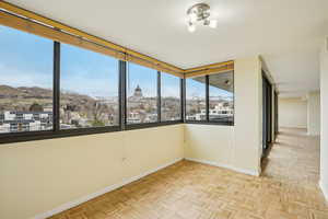 Empty room with a mountain view and parquet flooring