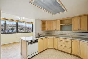 Kitchen with a mountain view, light wood finish cabinets, white appliances, a peninsula, and decorative backsplash
