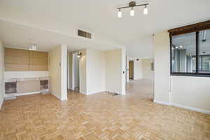 Spare room with parquet flooring and baseboards