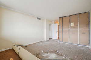 Unfurnished bedroom featuring ornamental molding, a closet, and carpet flooring