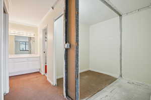 Corridor featuring ornamental molding and baseboards