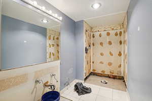Full bath with a stall shower and light tile patterned flooring
