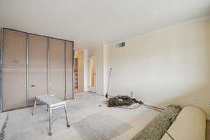 Unfurnished bedroom with a closet and crown molding