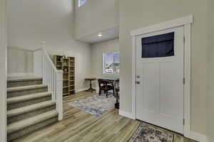 Entryway with light wood-style floors, a high ceiling, and recessed lighting