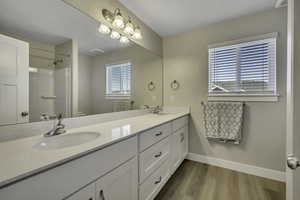 Full bathroom featuring double vanity and light wood-style floors
