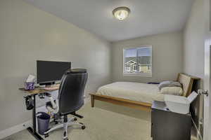 Bedroom with a desk and light colored carpet