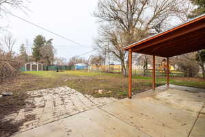 Fenced backyard with a patio area, a shed, and a playground