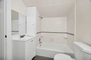 Bathroom with vanity, bathing tub / shower combination, and dark wood-style flooring