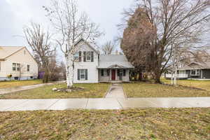 View of front of property featuring a front yard and a chimney