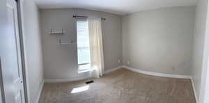 Spare room featuring light colored carpet and baseboards