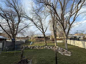 View of yard with a trampoline, a playground, and a residential view