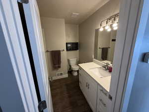 Bathroom featuring a textured ceiling, vanity, and dark wood finished floors