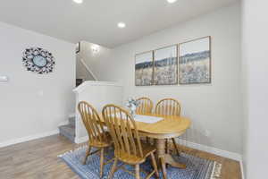 Dining area with wood-type flooring and recessed lighting