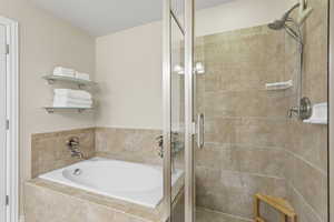 Primary Bathroom featuring a stall shower and a garden tub