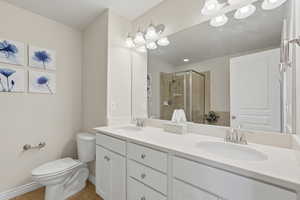 Primary bath featuring double vanity, a stall shower, and light tile patterned floors