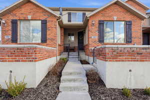 View of front of property with brick siding and an enclosed patio.