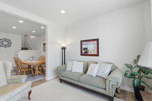 Living area with light wood-style floors and recessed lighting