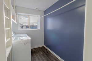 Laundry area featuring dark wood-style flooring and independent washer and dryer
