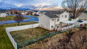 Back of house with a fenced backyard, a residential view, a shingled roof, and a deck with mountain view