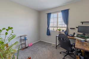Carpeted office space featuring baseboards
