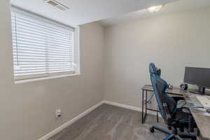 Office with baseboards and dark carpet