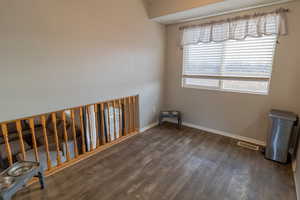 Unfurnished room with dark wood-type flooring and baseboards