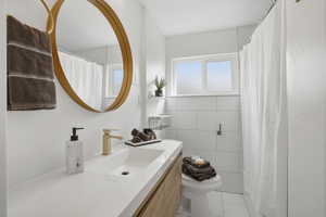 Upstairs Bathroom with vanity, tile walls, curtained shower, and light tile patterned floors