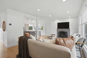 Living area with light wood-style flooring, a fireplace, and recessed lighting