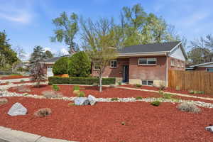 View of front of home with brick siding, a garage, and a shingled roof