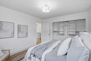 upstairs Bedroom with wood finished floors and a closet