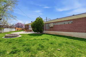 Back of property with a fire pit, brick siding, and a patio area
