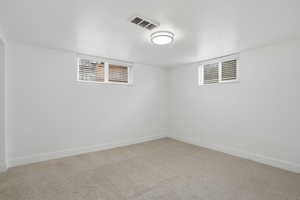 Basement bedroom featuring carpet flooring and a textured ceiling