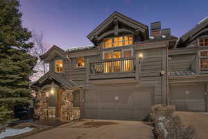 View of front facade with a balcony, concrete driveway, and an attached garage