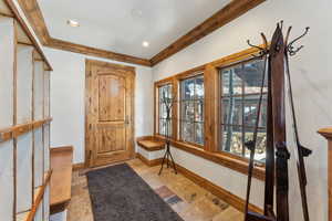Foyer featuring stone tile flooring and ornamental molding