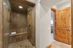 Bathroom with a stall shower, recessed lighting, and a textured wall