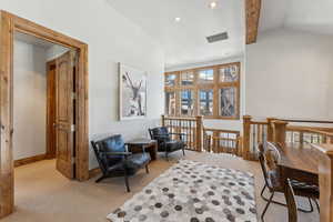 Sitting room featuring light colored carpet, lofted ceiling with beams, and recessed lighting