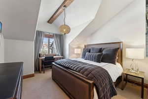 Bedroom featuring beamed ceiling and light colored carpet