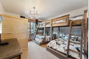 Bedroom featuring access to outside, light colored carpet, a sauna, and suspended lighting