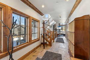 Foyer entrance with ornamental molding, recessed lighting, and light stone finish flooring