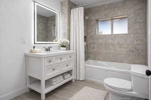 Full bath with light wood-style flooring and vanity