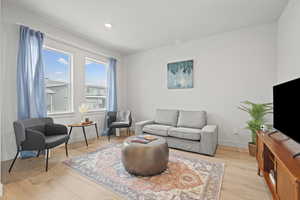 Formal living room off of entry featuring light wood LVP floors and recessed lighting