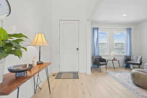 Formal living room off of entry featuring light wood LVP floors and recessed lighting