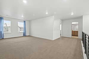 Bonus loft area featuring light colored carpet and recessed lighting