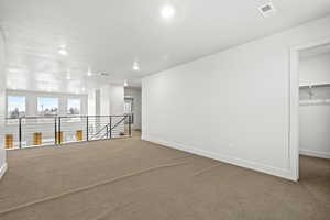 Bonus loft area featuring light colored carpet and recessed lighting