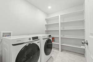 Laundry area featuring washer and dryer, built in shelving, and recessed lighting