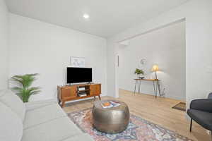 Formal living room off of entry featuring light wood LVP floors and recessed lighting