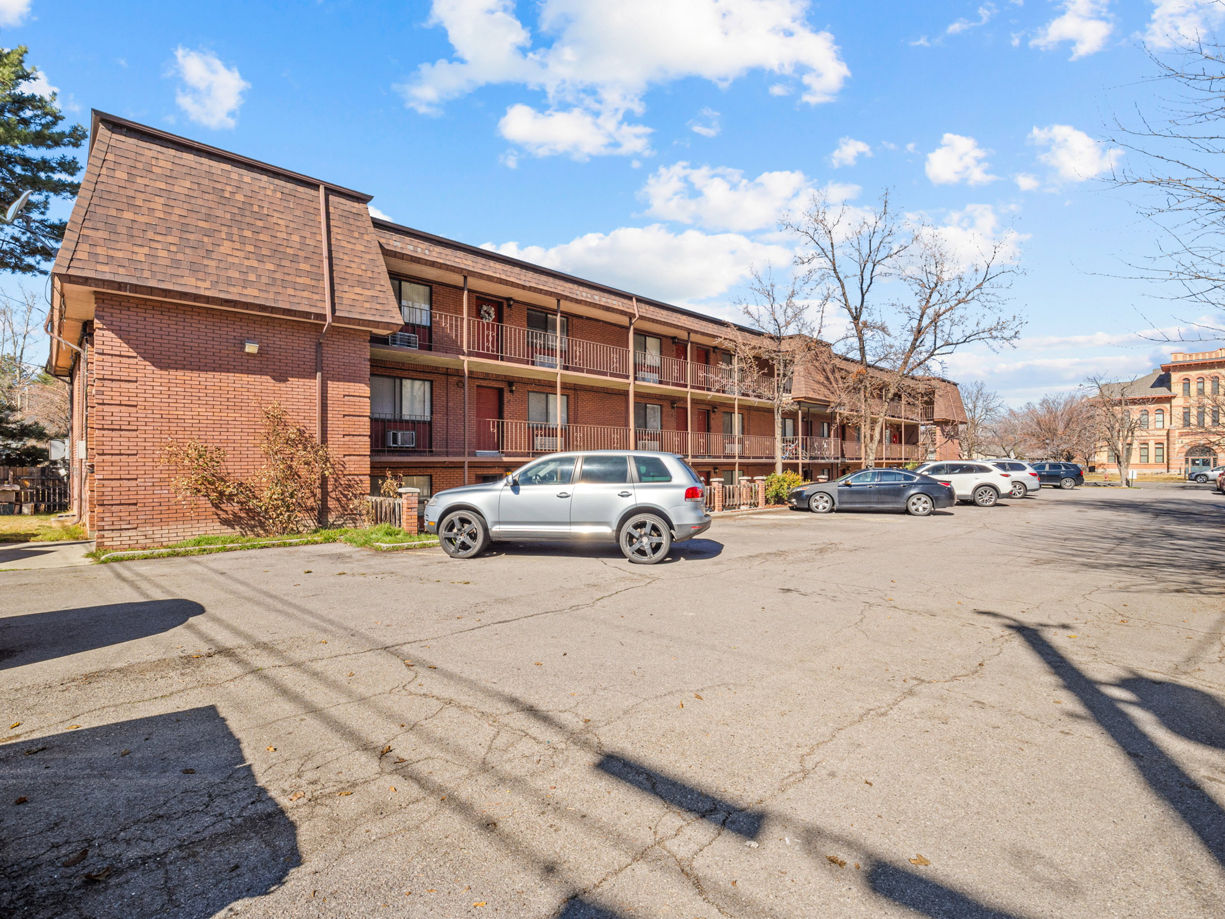 View of apartment building / complex featuring uncovered parking
