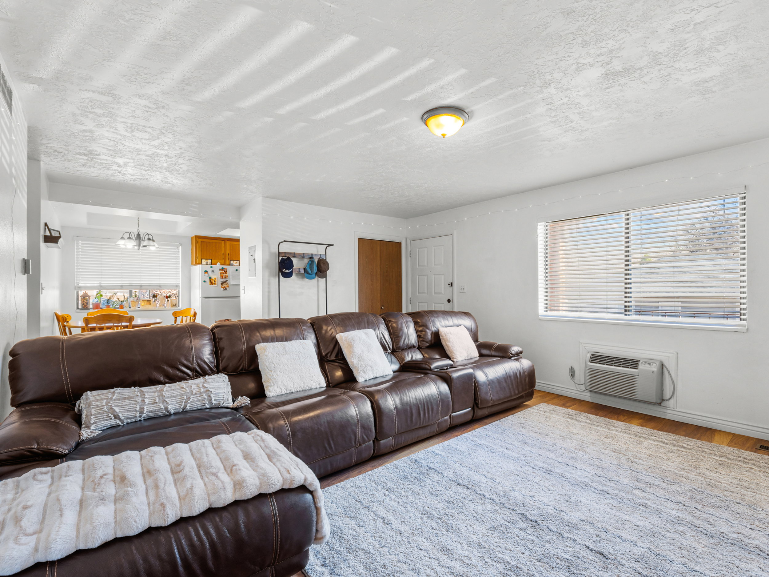 Living room featuring wood finished floors, a textured ceiling, and hanging lights