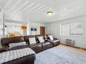 Living room featuring wood finished floors, a textured ceiling, and hanging lights